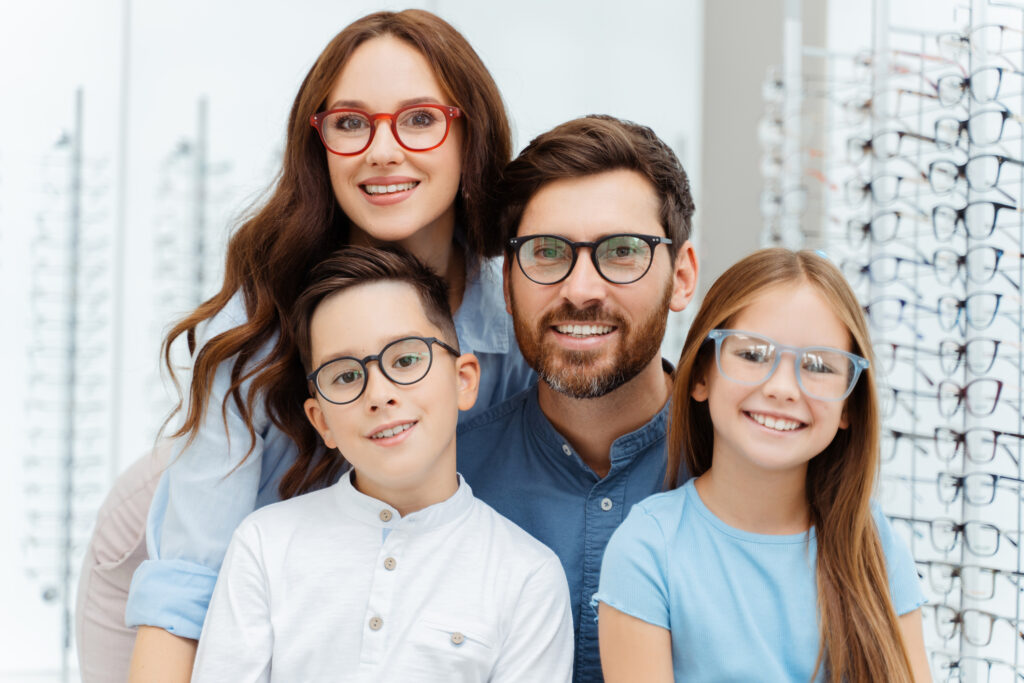 A family smiling with their new eyeglasses.